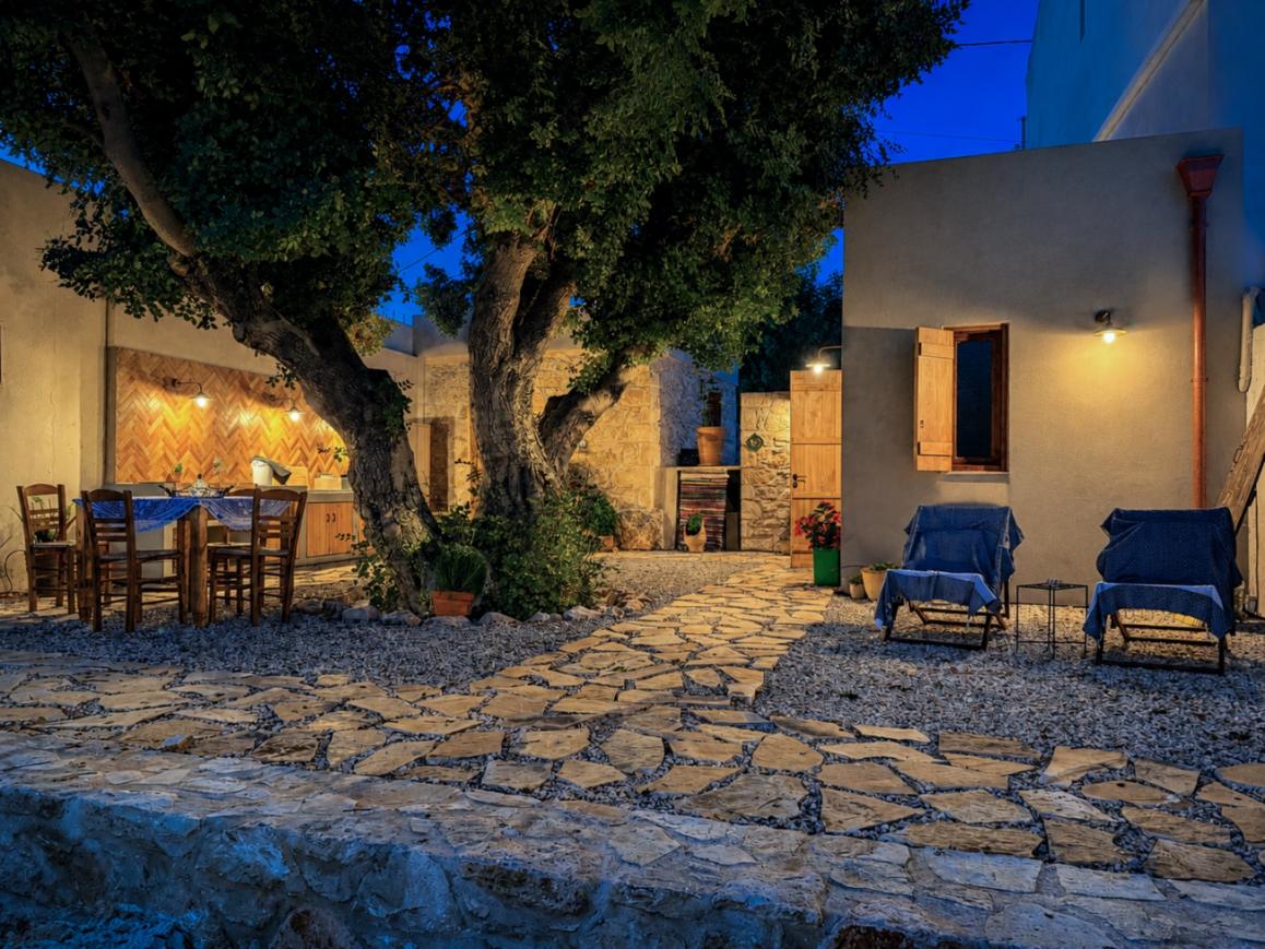 The courtyard at blue hour, the old carob tree lit from below