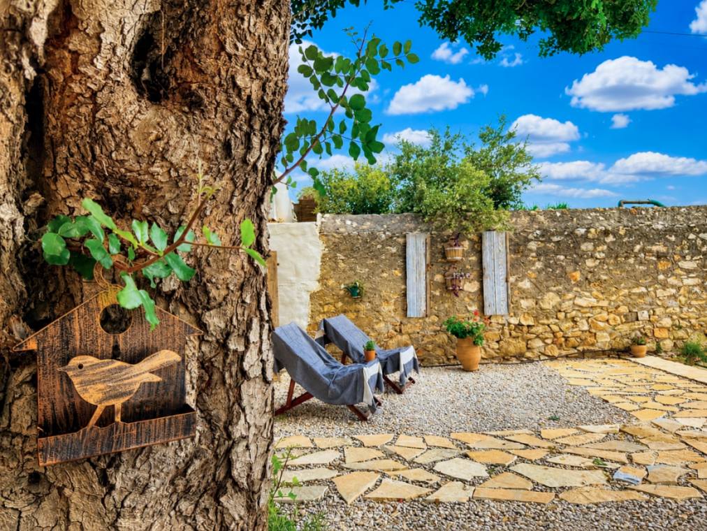 Two deck chairs in the shade against the dry-stone wall